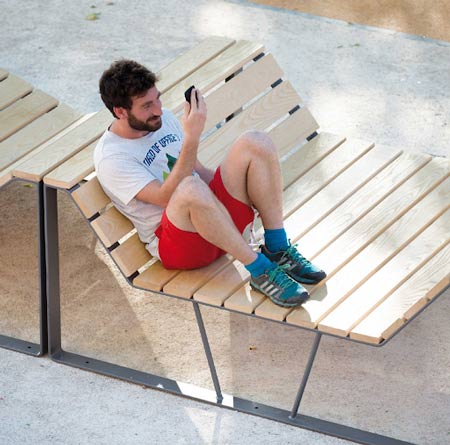 Homme assis sur un banc multifonction.