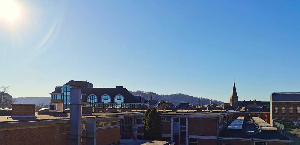 Photo prise en hauteur dans un bâtiment de la HEAJ avec une vue sur les toits