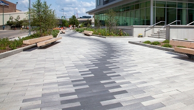 Pavé moderne gris et blanc sur place publique. Motif linéaire.